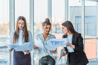 Ofiste üç iş çocuklar. Dikkatle bakıyor sizin elinizde kağıt tutun