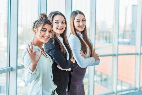 Drei Mädchen, die ihre effektive Integration und ihren Erfolg im Geschäftsleben demonstrieren. — Stockfoto