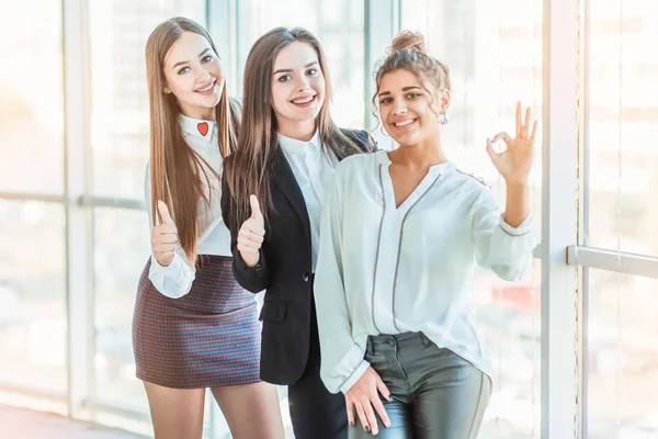 Junge hübsche Business-Girls zeigen eine gute Geste. in klassischer Kleidung gekleidet — Stockfoto