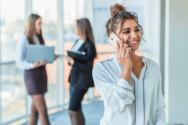 İş kadını ofiste bir smartphone-e doğru konuşmak. Mutlu gülümseyen beyaz iş kadını ile meşgul — Stok fotoğraf