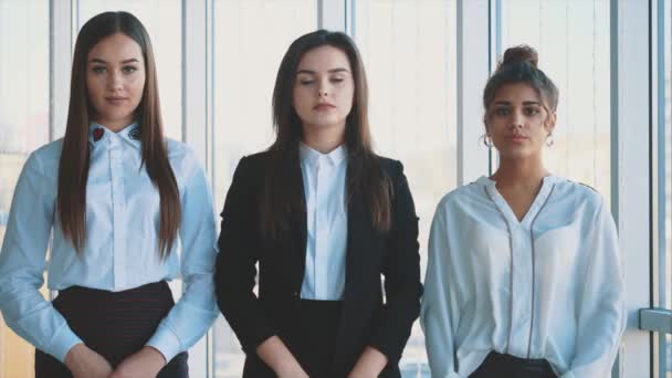 Con placer, tres mujeres de negocios cruzan los brazos, mirando a la cámara . — Vídeo de stock