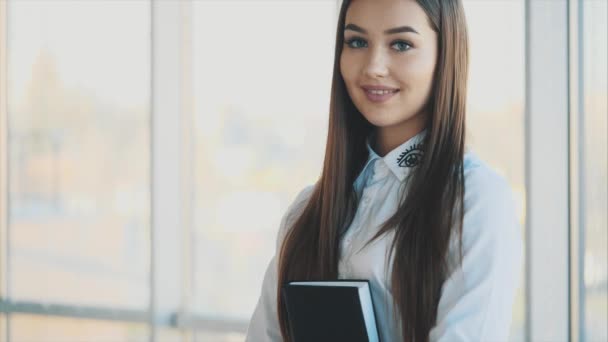 Mooie zakenvrouw is op zoek naar camera en glimlachen tijdens het werken in het kantoor — Stockvideo