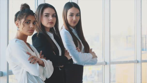 Con placer, tres mujeres de negocios cruzan los brazos, mirando a la cámara — Vídeo de stock