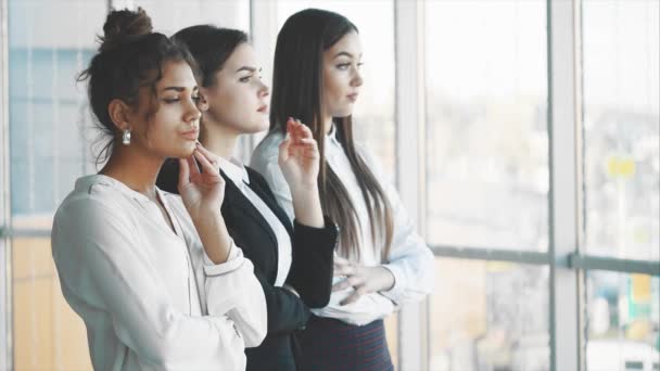 Con placer, tres mujeres de negocios cruzan los brazos, mirando a la cámara . — Vídeo de stock