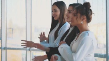 Memnuniyetle, üç iş kadın kolları, kameraya bakarak çapraz. Giymiş beyaz bluz.
