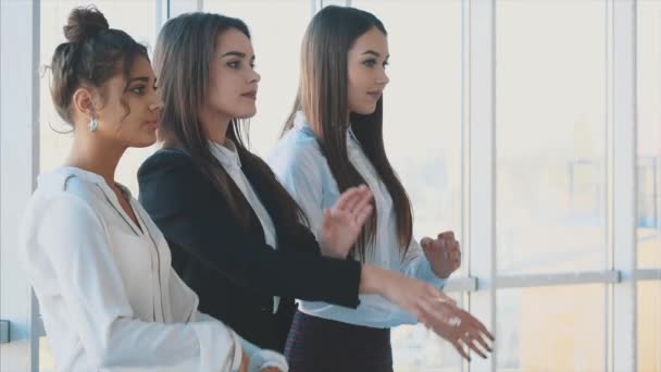 Con piacere, tre donne d'affari incrociano le braccia, guardando la macchina fotografica. Vestita con camicette bianche . — Video Stock