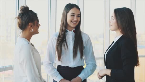 drei Business-Girls plaudern lächelnd, wenn sie Erfolg im Geschäft haben.