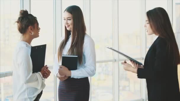 Grupo de amistosos tres personas de negocios multiétnicos de pie en el salón de oficinas, mantener documentos, estudio de informe financiero . — Vídeos de Stock