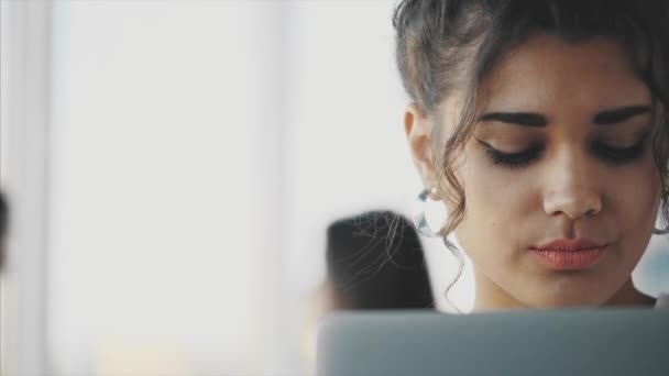 Hermosa mujer de negocios morena en un traje blanco de una computadora portátil en la mano al aire libre . — Vídeos de Stock