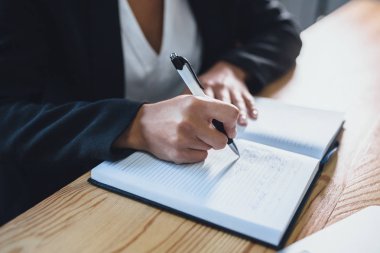 Akıllı iş kız ofiste çalışıyor. Bu sırada, şirketin büyüme için önemli adımları oluşturur. Yazılı bir not defteri olarak.