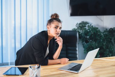 Bir bilgisayarda çalışan genç iş kadını yoruldu.