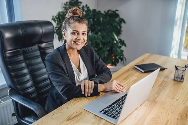 Young beautiful business lady dressed in a business stylish black jacket.