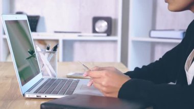 Kız ofiste oturan şık giysiler giymiş.