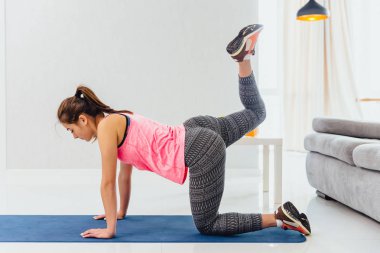 Genç kız germe egzersiz yapmak. Yoga Lila halı tarafından işgal külotlu çorap uzun saçlı güzel zarif kızlar.