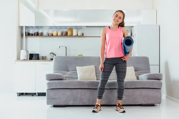 Portrait of an attractive woman wearing a blue jogging or fitness kit after work at home or at the club.