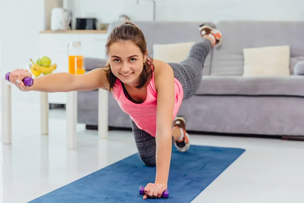 Young girl doing stretching exercise. At the same time getting a huge pleasure smiling. — Stock Photo, Image