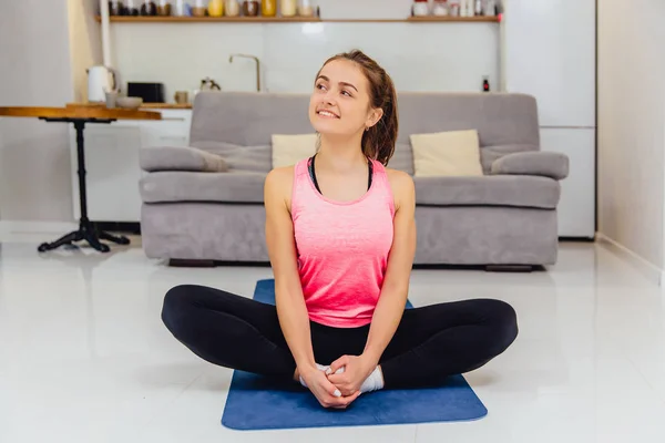 A young adult girl wearing sportswear at home is busy