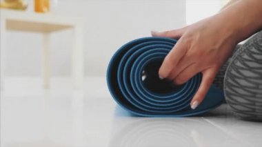 Evde oturma odasında çalıştıktan sonra mavi koşu veya bir fitness mat güzel kadın giyinmiş bir genç yakın çekim.