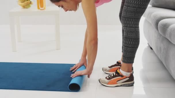 Zbliżenie: kobiece skomplikowane Joga niebieski lub Mata fitness po pracy w domu w salonie. — Wideo stockowe