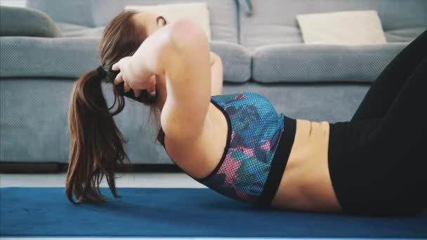 Zdravá žena, která dělá fyzické cvičení s sportovní oblečení a doma. Zdravý životní styl. — Stock video