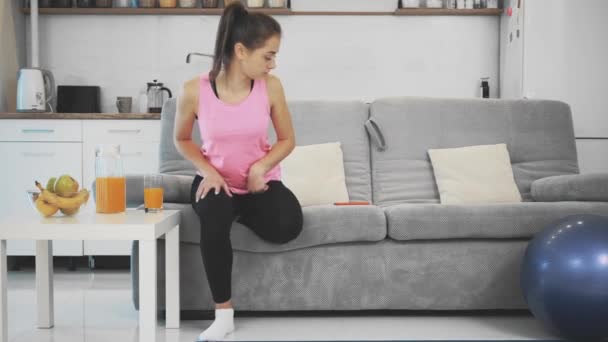 After a home fitness the girl enjoys orange juice. — Stock Video