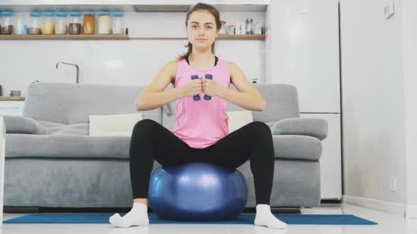 La ragazza sedeva sulla palla facendo vari esercizi sportivi . — Video Stock