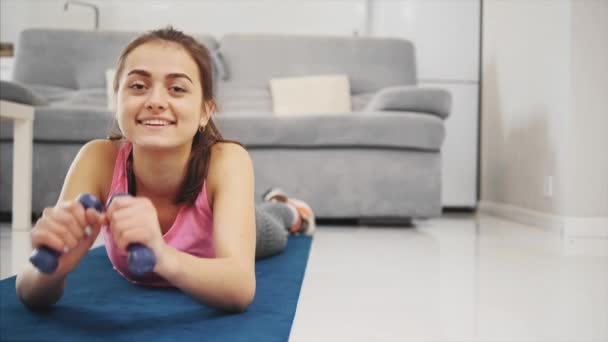 Egy fáradt lány fekszik a padlón, és a mosoly — Stock videók