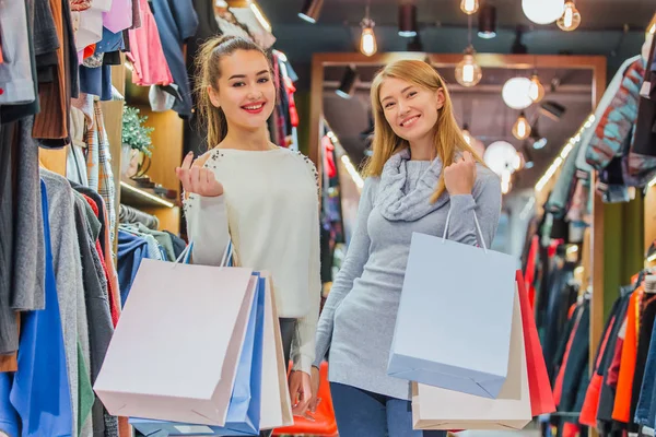 Mujeres felices con bolsas de compras en la tienda — Foto de Stock