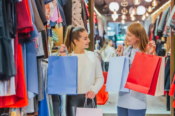 Щасливі жінки з сумками в магазині — стокове фото
