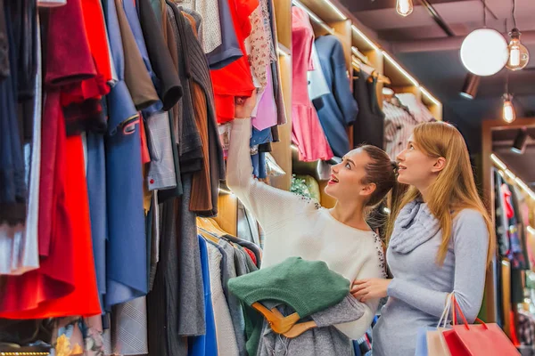 Girlfriends in the store after making their purchases have found for themselves another good thing. — Stock Photo, Image