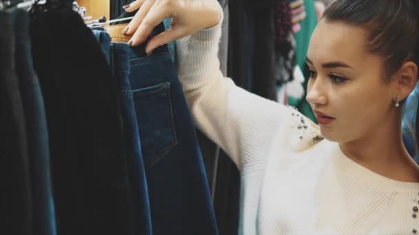 Amikor egy fiatal lány megy a boltba, van egy vágy, hogy találni egy olyan ruhát. — Stock videók