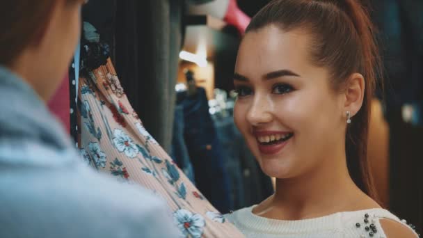 Jeunes belles femmes dans le marché hebdomadaire des vêtements sont les meilleurs amis . — Video