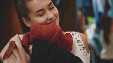 Genç bir kız mağazada alışveriş. Ona uygun şeyler buldum. Yumuşak bir bez zevk