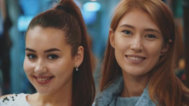 Dos hermosas mujeres jóvenes, disfrutando de las compras en la tienda, están muy contentas de recibir una enorme satisfacción . — Vídeos de Stock