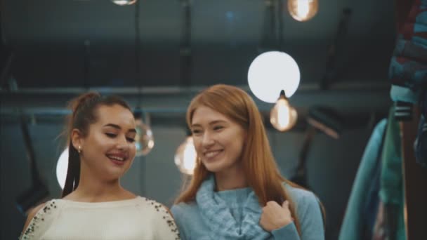 Dos hermosas mujeres jóvenes, disfrutando de las compras en la tienda, están muy emocionados de recibir un gran placer de ir de compras . — Vídeo de stock