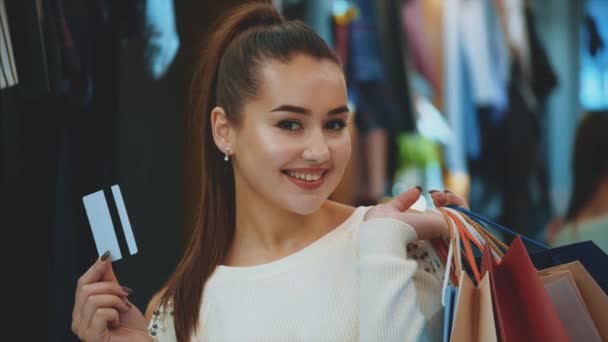 Young girl in shop with shopping and credit card. — Stock Video