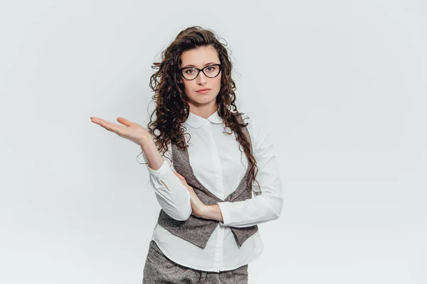 Belle jeune femme debout lève le bras droit. Regardant comment quelque chose tient dans un fond blanc . — Photo