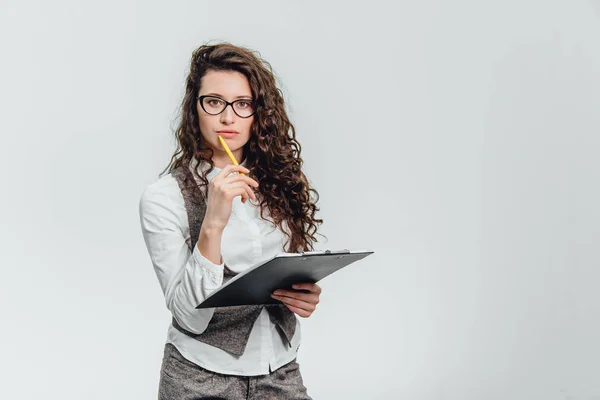 Happy beautiful young business woman standing. Holding clipboard over white background . — Stock Photo, Image