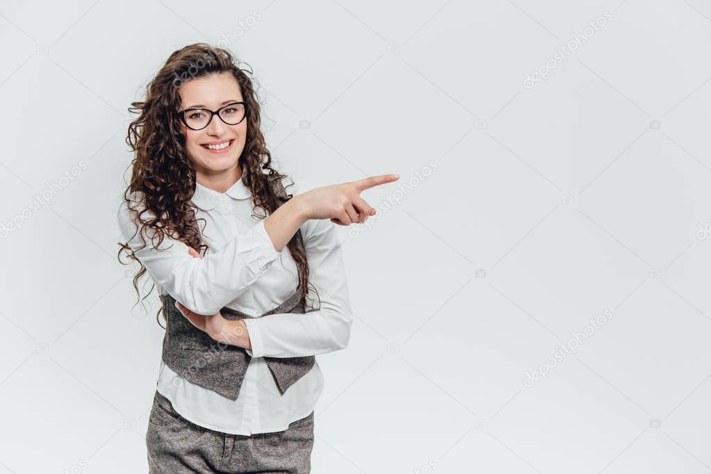Beautiful young woman standing up and raising two hands. Looking how something holds in a white background.