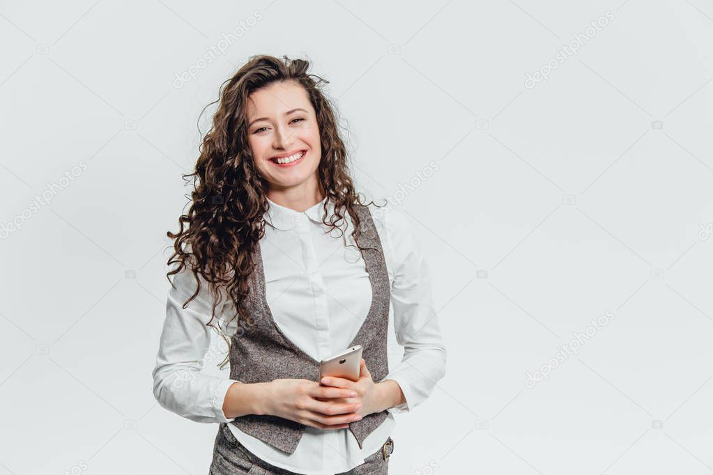Young business lady with beautiful curly hair on a white background rejoices.