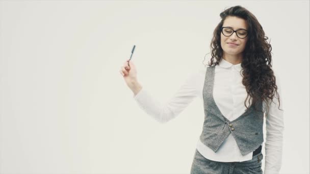 Portrait d'une belle brune jeune. Une fille à la peau claire avec une coiffure poilue est sérieuse. Épingle le marqueur dans le côté gauche . — Video