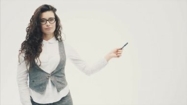 Güzel esmer genç portresi. Açık tenli kız Kıllı bir saç modeli ile ciddi bir durum. İşaretçiyi sol tarafında sabitler. Bir süre sonra o elini düşürür.