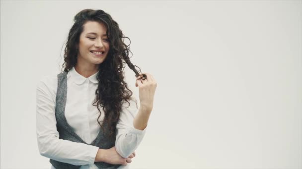 Mujer de negocios sonriente vestida con camisa blanca. Ubicado sobre un fondo blanco y sonríe genuinamente. — Vídeo de stock