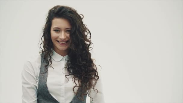 Mujer de negocios sonriente vestida con camisa blanca. Ubicado sobre un fondo blanco y sonríe genuinamente. — Vídeos de Stock