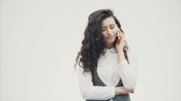 Mladá podnikatelka s krásné kudrnaté vlasy na bílém pozadí. Během toho citově mluví po telefonu s různými výrazy obličeje. — Stock video