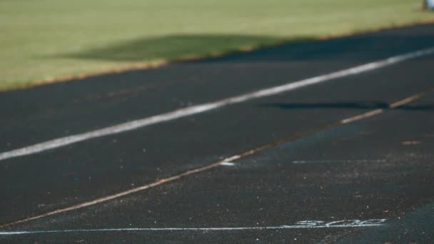 女性のランナーは トラックに負傷した右足を開催します 停止を持つ彼が手筋が彼が痛い — ストック動画