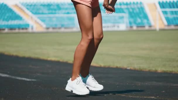 Sport, oefeningen buiten. Meisje doet die zich uitstrekt over stadion. Opzij buigen. — Stockvideo