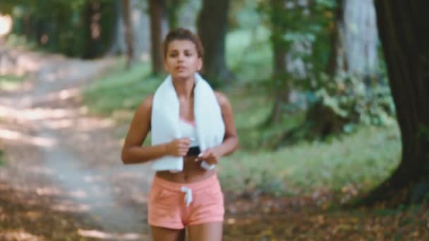 Joven hermosa y en forma mujer deportiva después de correr entrenamiento de pie en el parque feliz y relajado en el concepto de estilo de vida saludable  . — Vídeo de stock