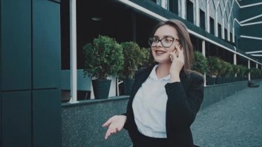 İş elbiseleri yürüyüş çok akıllı iş kız. Bu sırada o telefonda konuşuyor.