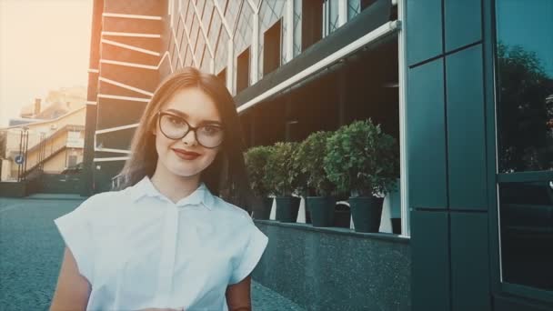 Una ragazza nel quartiere degli affari della città va a un incontro di lavoro. Giovane donna in abiti da lavoro. Stile di business . — Video Stock